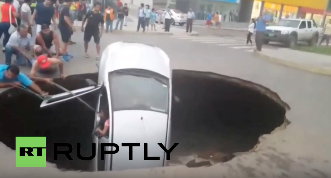 Image: Giant sinkhole swallows car with family still inside in Peru