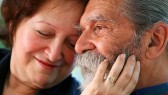 Affectionate old couple with the wife holding on lovingly to the husband's face. Focus on the husband's eyes. Concept: Elderly love.