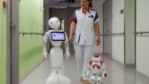 A-nurse-walks-with-Pepper-L-and-Zora-the-robots